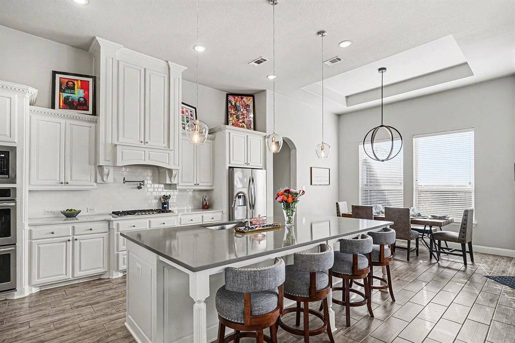 415 Silver Spur Trail Rockwall, TX 75032 - Photo 10 of 40 a kitchen with stainless steel appliances granite countertop a table chairs sink and cabinets