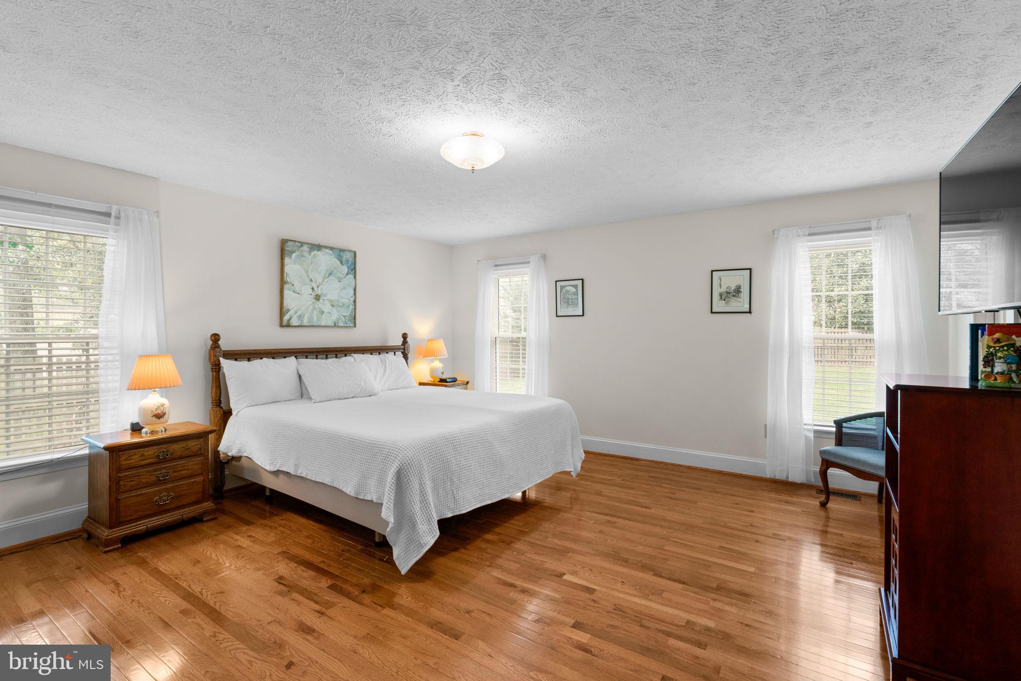 7884 Walnut Grove Road Severn, MD 21144 - Photo 20 of 42 a spacious bedroom with a bed and a table in it