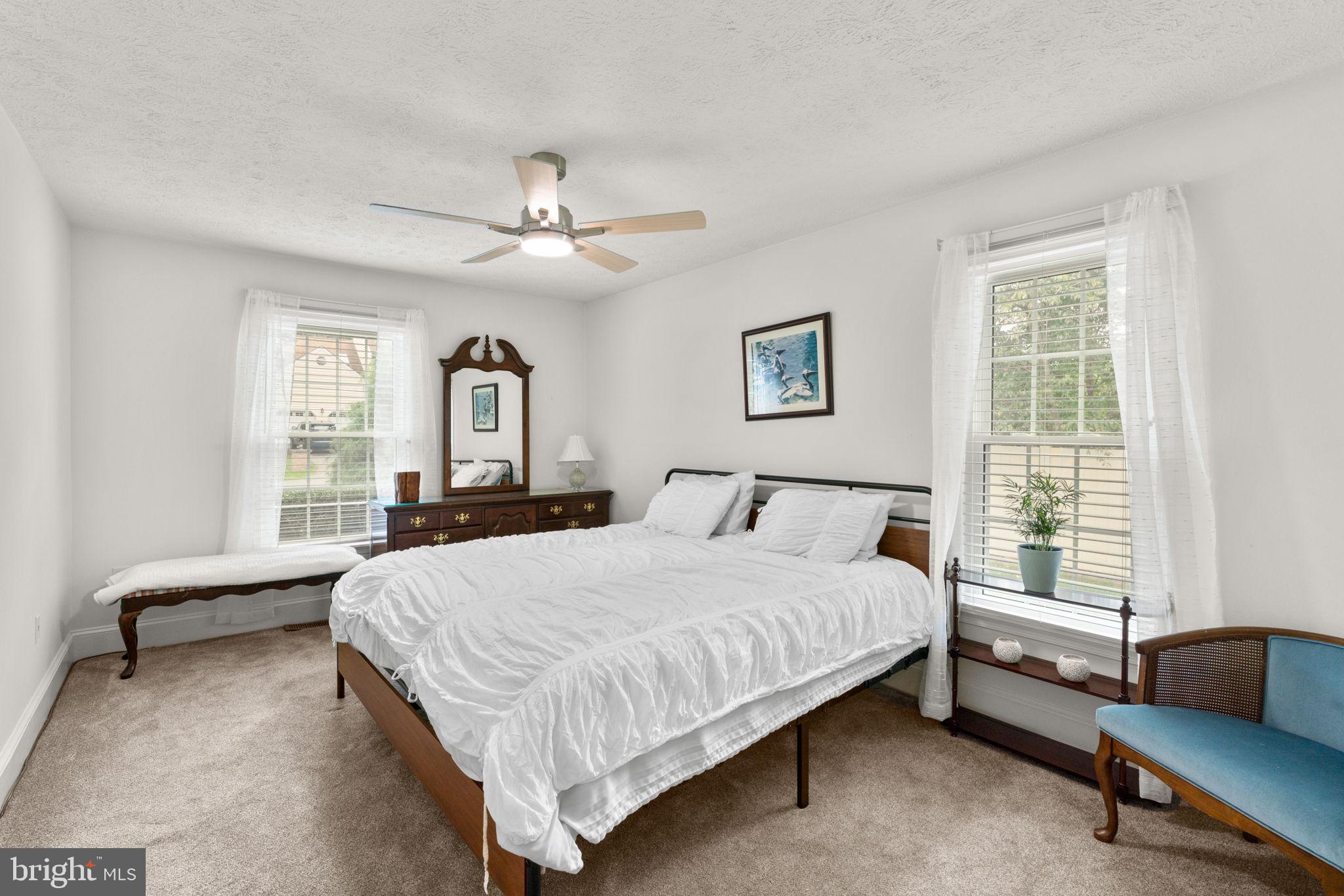 7884 Walnut Grove Road Severn, MD 21144 - Photo 24 of 42 a bedroom with a large bed couch and two windows