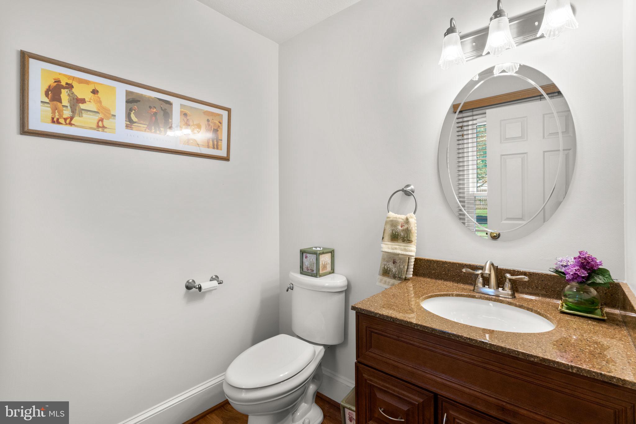 7884 Walnut Grove Road Severn, MD 21144 - Photo 30 of 42 a bathroom with a granite countertop toilet a sink and a mirror