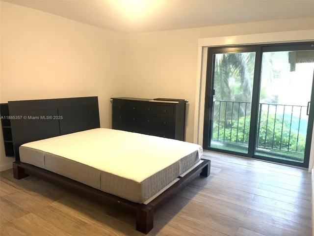 a bed sitting in a bedroom with a large window