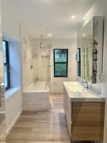 a bathroom with a bathtub a double vanity sink and a shower