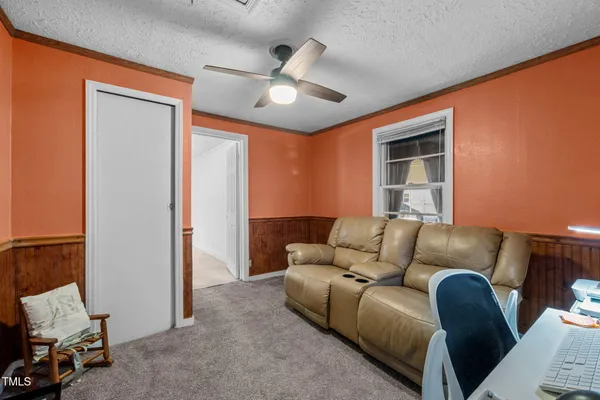 a living room with furniture and a ceiling fan