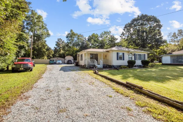 a view of a house with a yard patio and a tree