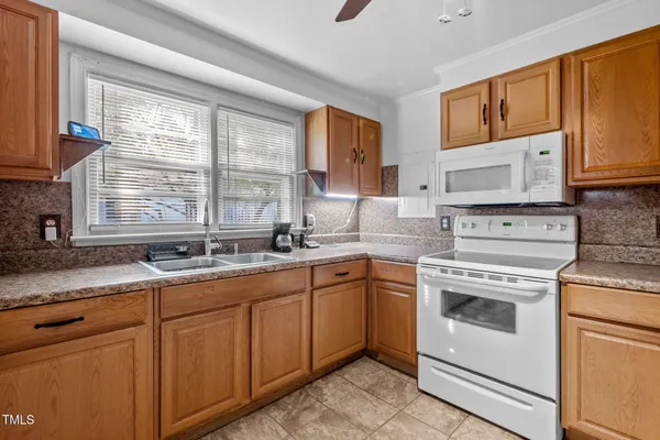 a kitchen with granite countertop cabinets stainless steel appliances a sink and window