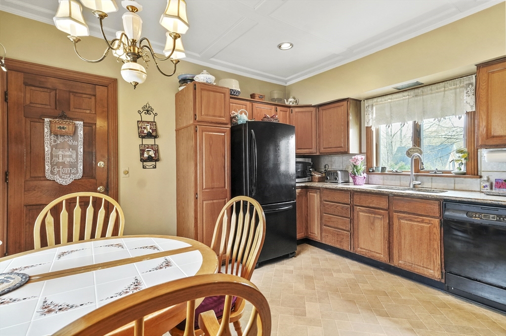 6 Prospect Street Merrimac, MA 01860 - Photo 2 of 40 a kitchen with stainless steel appliances granite countertop a refrigerator a sink a stove a dining table and chairs with wooden floor