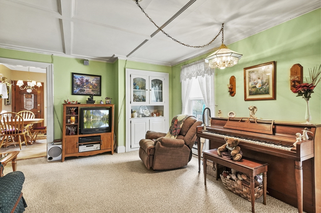 6 Prospect Street Merrimac, MA 01860 - Photo 9 of 40 a living room with furniture a flat screen tv and a chandelier
