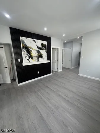 an empty room with wooden floor and painting on the wall