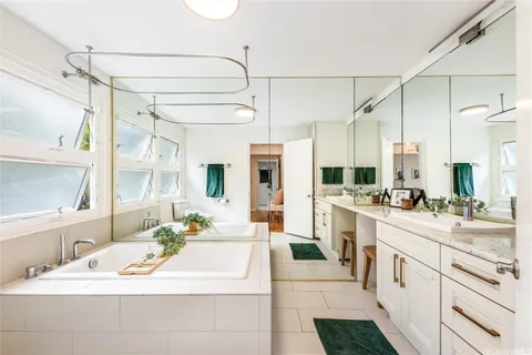 a bed sitting in a spacious bedroom next to a window