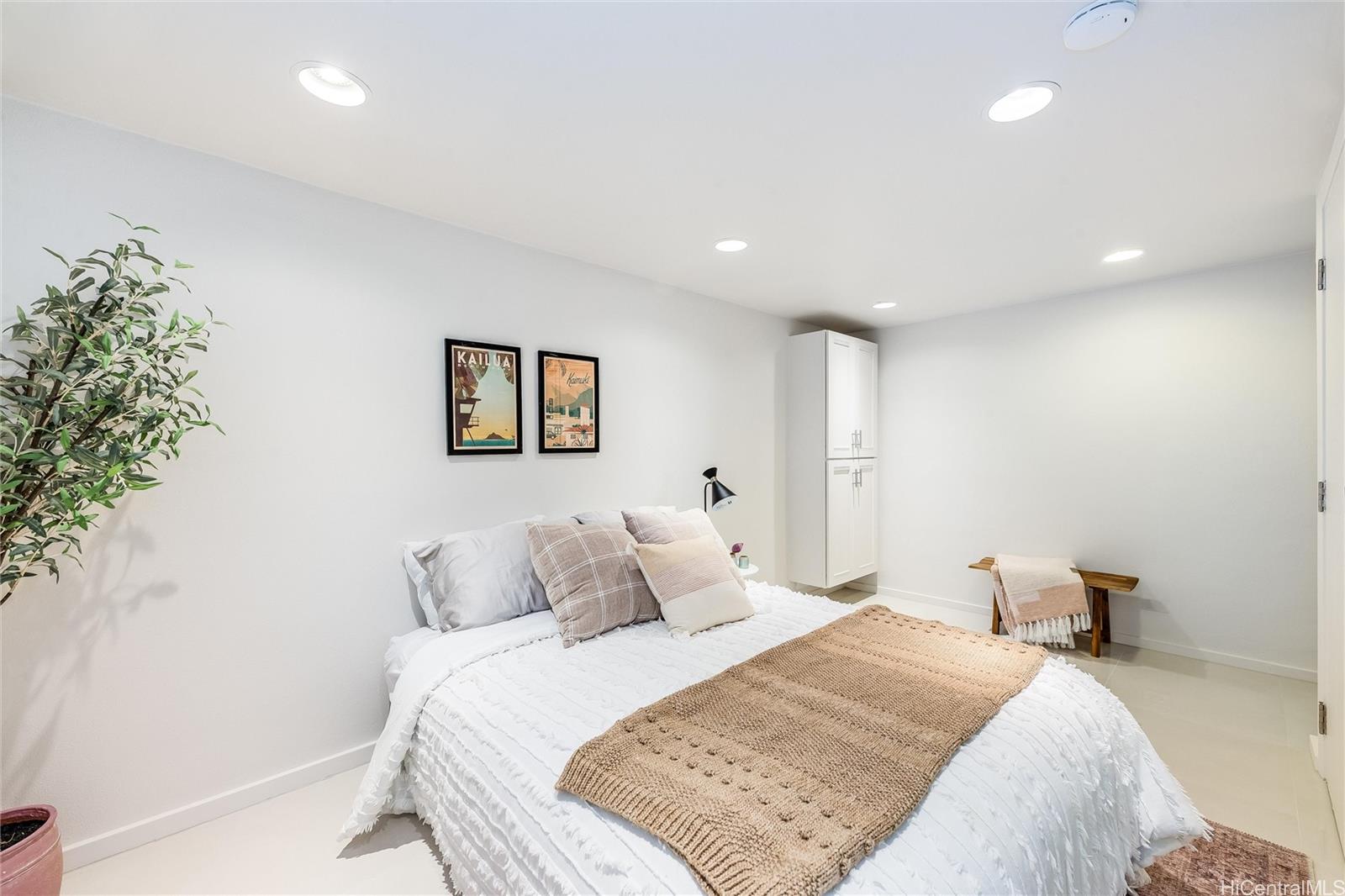 532 Portlock Road Honolulu, HI 96825 - Photo 21 of 25 a bedroom with a large bed and a potted plant