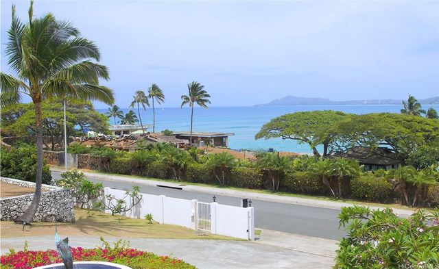 an aerial view of a house with yard and ocean view