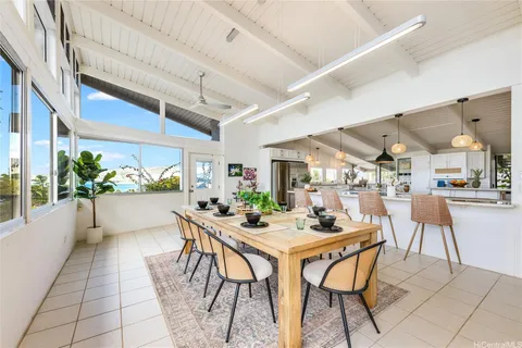 a dining hall with stainless steel appliances kitchen island granite countertop a table and chairs
