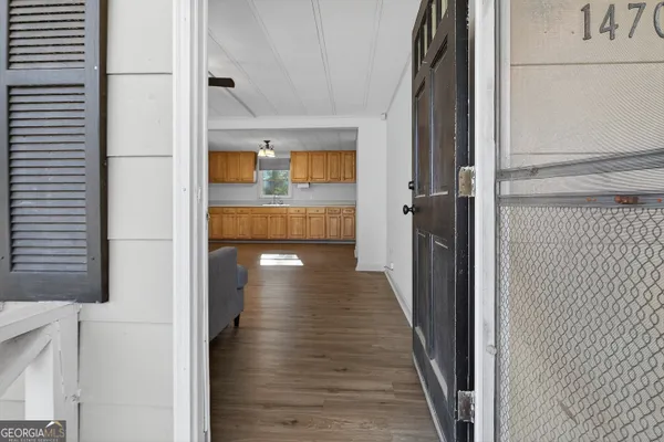 a view of a hallway with wooden floor and staircase