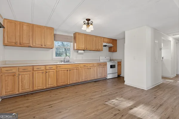 a kitchen with white cabinets white stainless steel appliances and sink