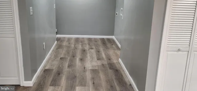 an empty room with wooden floor and entrance