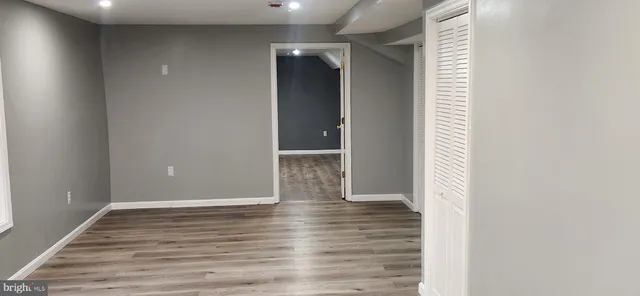 a view of empty room with wooden floor and fireplace