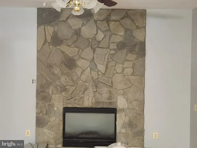 a view of an empty room with a window and fireplace