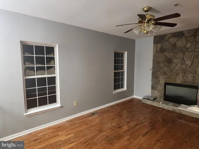 a view of empty room with wooden floor and fireplace