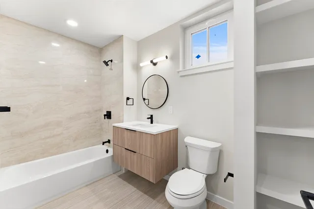 a bathroom with a toilet a sink a mirror and bathtub