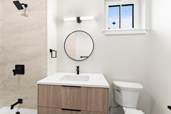 a bathroom with a sink a toilet and mirror
