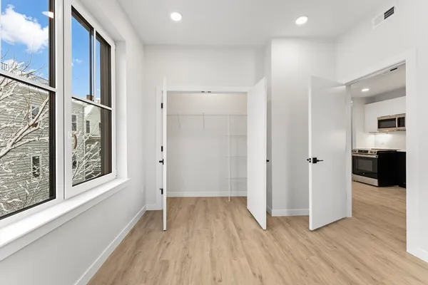 an empty room with wooden floor and windows