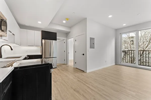 a kitchen with stainless steel appliances granite countertop a refrigerator a sink dishwasher and a stove with wooden floor