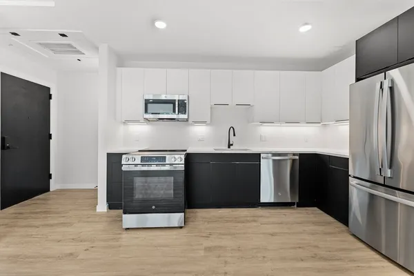 a kitchen with stainless steel appliances a stove a sink and a refrigerator