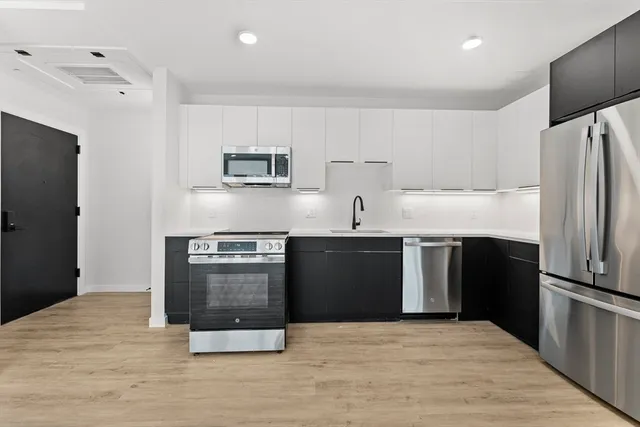 a kitchen with stainless steel appliances a stove a sink and a refrigerator