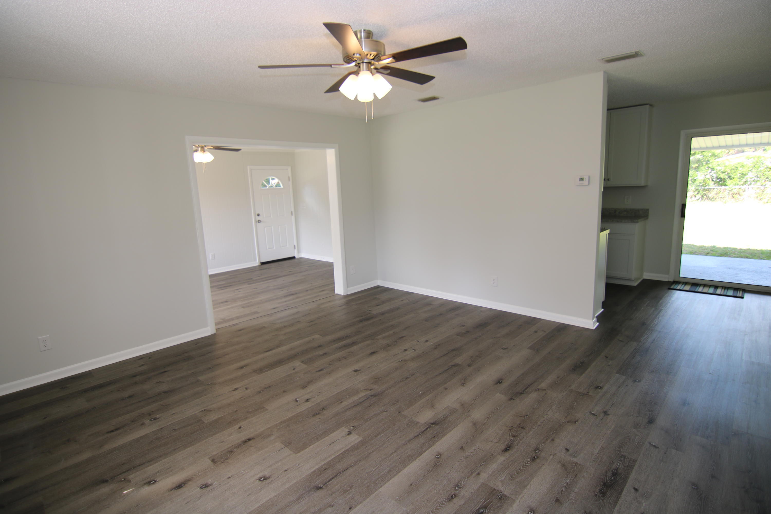 10624 Dodd Road Jacksonville, FL 32218 - Photo 4 of 21 an empty room with wooden floor and windows