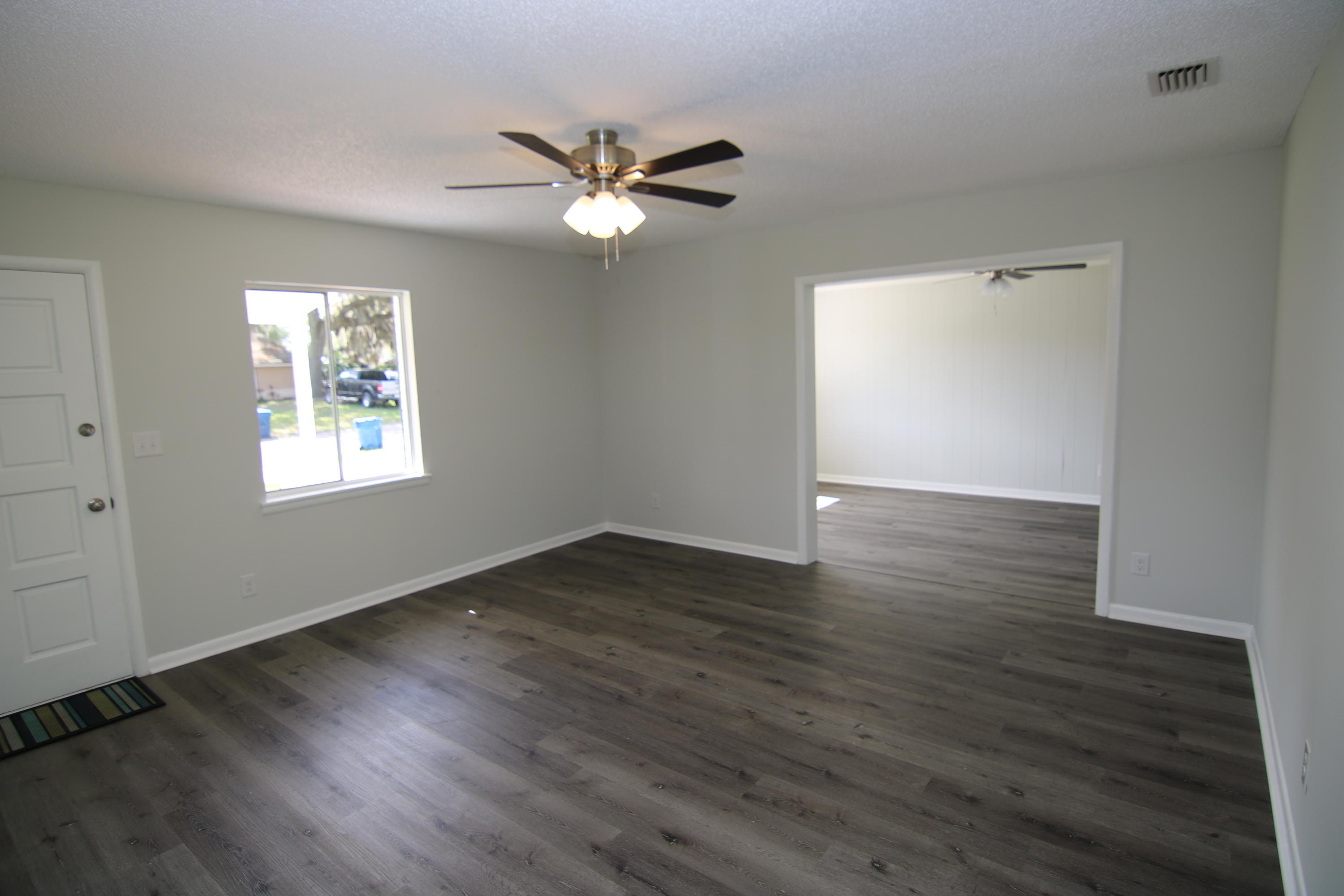 10624 Dodd Road Jacksonville, FL 32218 - Photo 7 of 21 a view of an empty room with wooden floor and a window