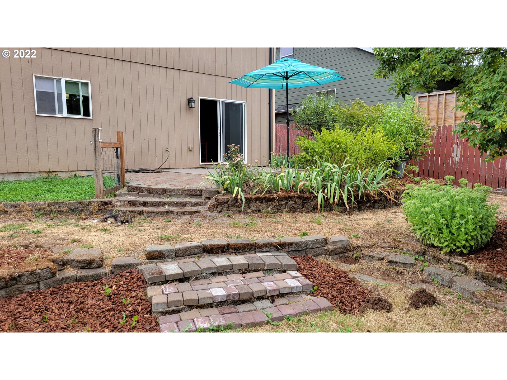 816 Southeast Darrow Road Estacada, OR 97023 - Photo 23 of 29 a backyard of a house with table and chairs under an umbrella