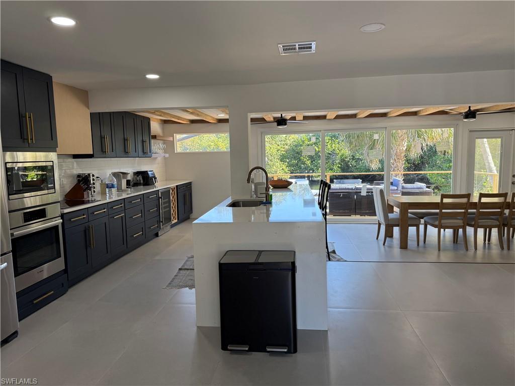 514 14th Street North Naples, FL 34102 - Photo 13 of 22 a kitchen with stainless steel appliances granite countertop a stove and a view of living room