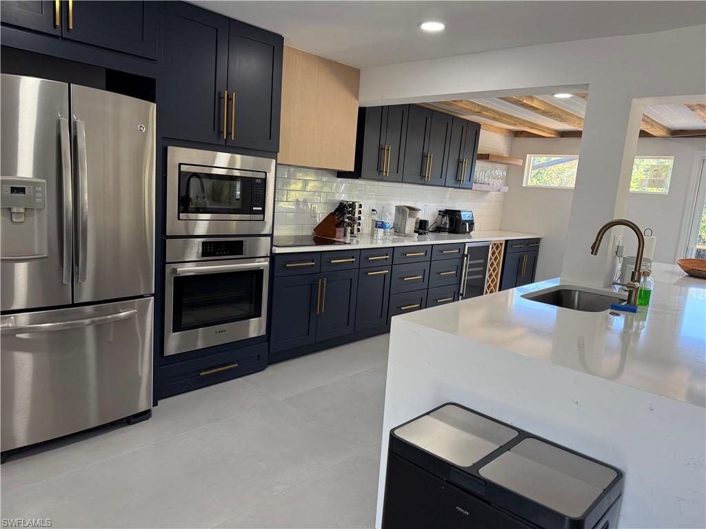 514 14th Street North Naples, FL 34102 - Photo 5 of 22 a kitchen with granite countertop a refrigerator stove and sink