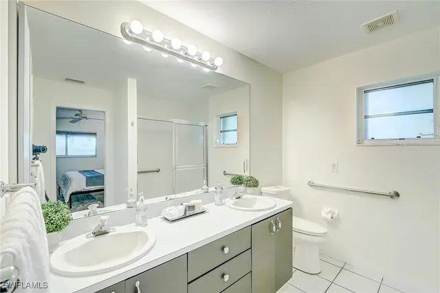 a bathroom with a granite countertop sink a toilet and a mirror