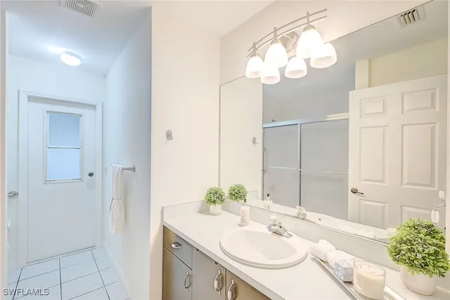 a bathroom with a sink a light fixture and a mirror