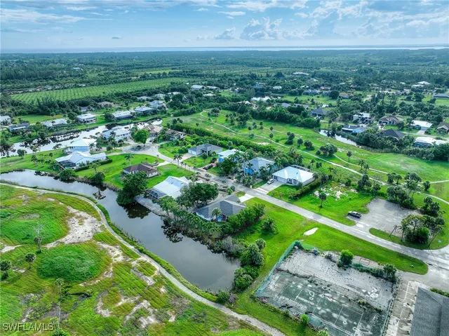an aerial view of residential houses with outdoor space and trees
