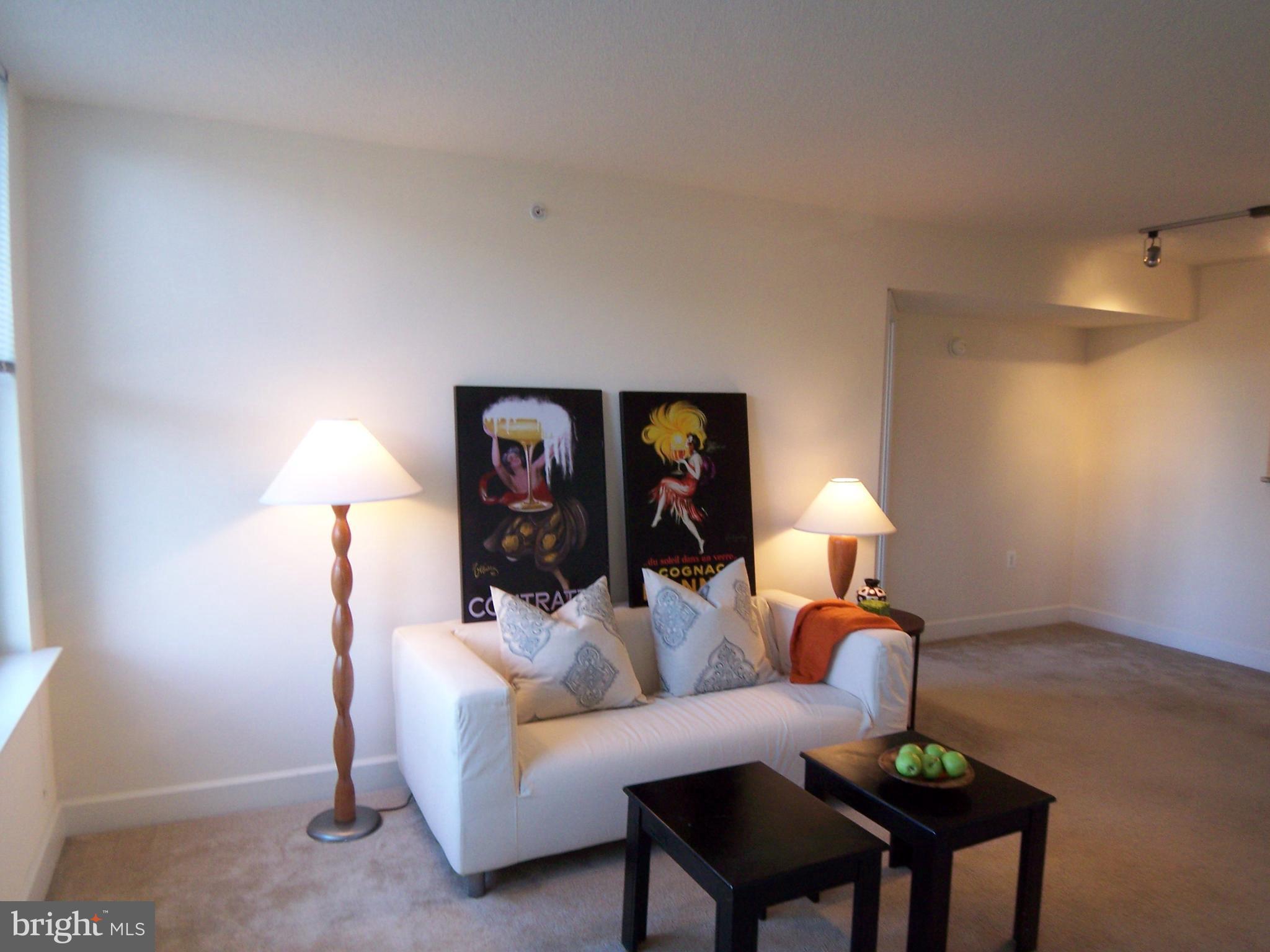 11800 Sunset Hills Road, Unit 608 Reston, VA 20190 - Photo 11 of 15 a living room with furniture and a lamp