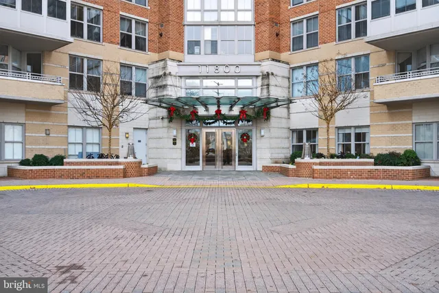 a view of an swimming pool with a lawn chairs and a dining table under an umbrella