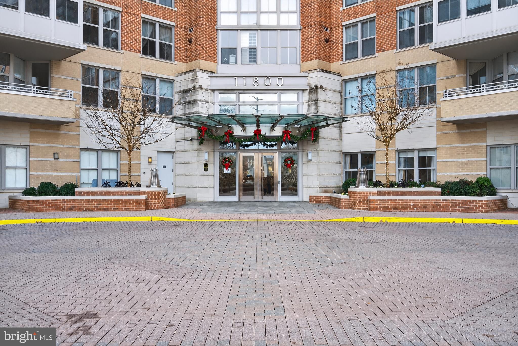 11800 Sunset Hills Road, Unit 608 Reston, VA 20190 - Photo 17 of 40 a view of an swimming pool with a lawn chairs and a dining table under an umbrella