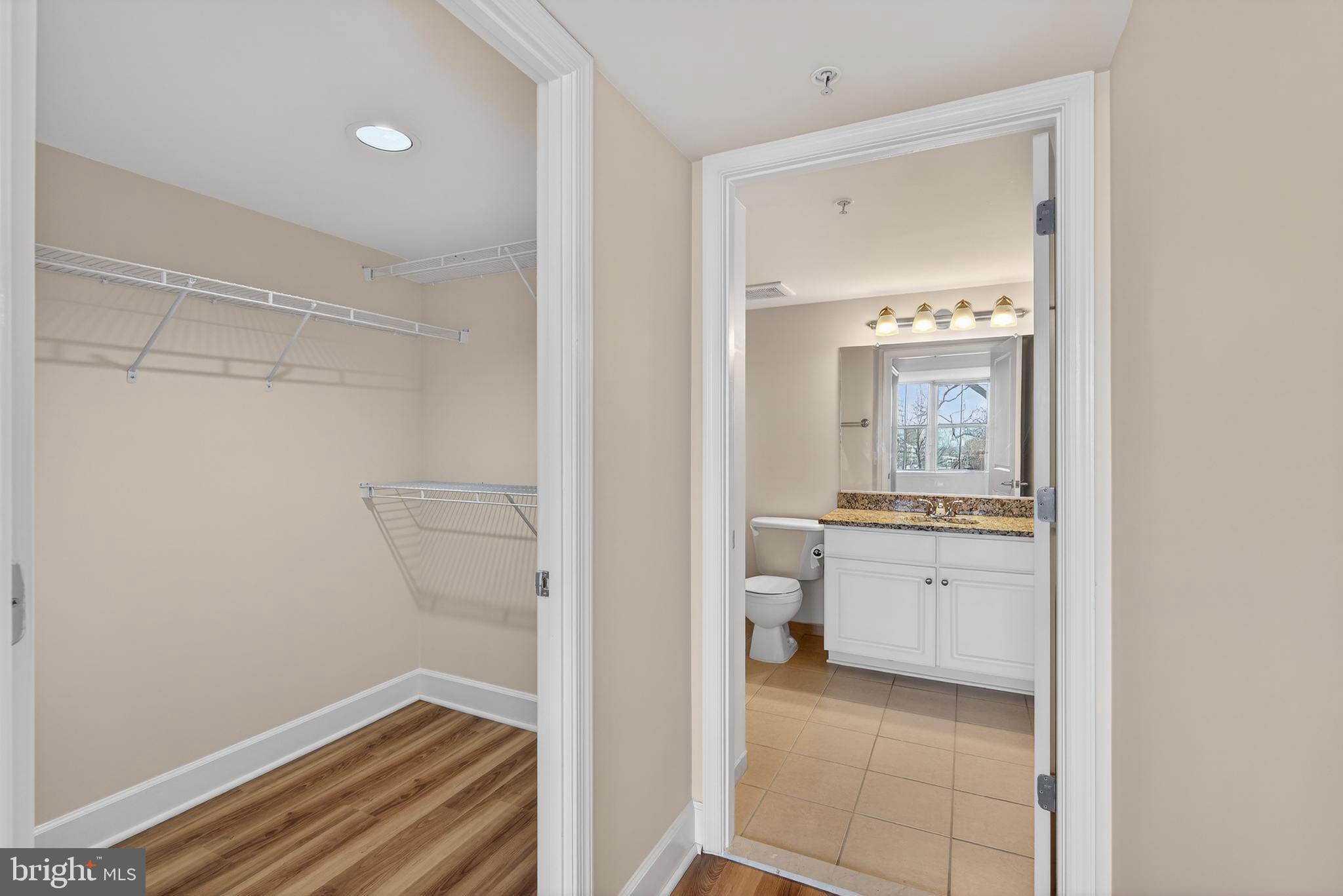 11800 Sunset Hills Road, Unit 608 Reston, VA 20190 - Photo 36 of 40 a bathroom with a granite countertop sink a toilet and a mirror