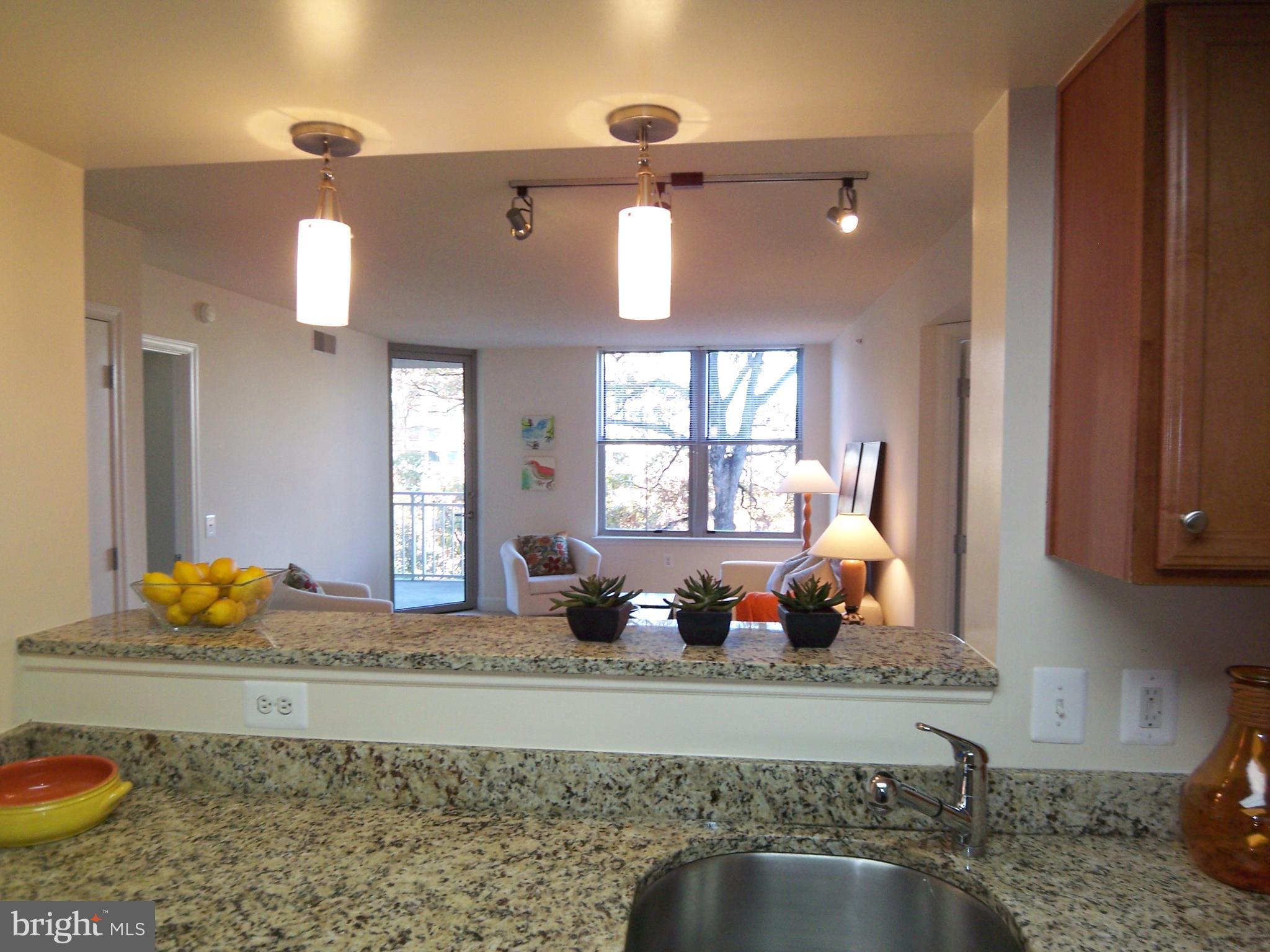 11800 Sunset Hills Road, Unit 608 Reston, VA 20190 - Photo 5 of 15 a kitchen with a granite countertop sink a stove and a granite counter top