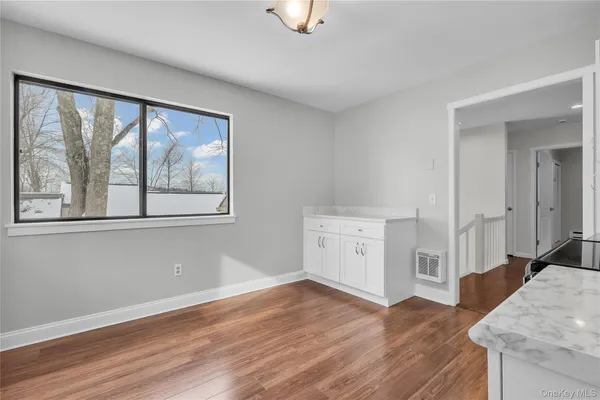 a view of empty room with wooden floor and fireplace