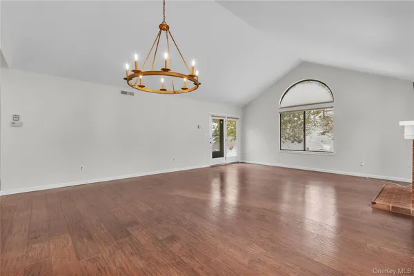 a view of a livingroom with wooden floor and a ceiling fan