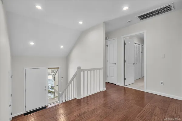 a view of a hallway with wooden floor