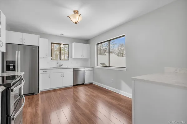 a kitchen with granite countertop white cabinets and stainless steel appliances