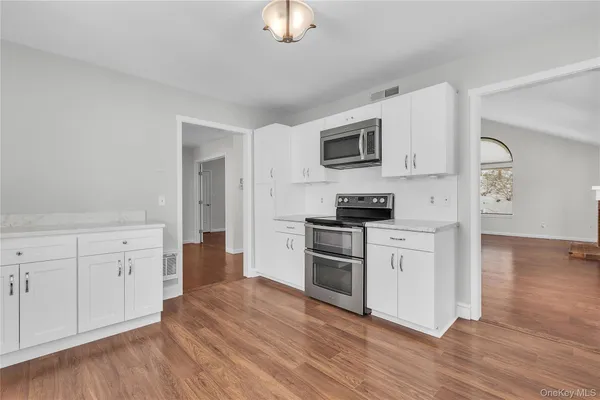 a kitchen with stainless steel appliances white cabinets and a refrigerator