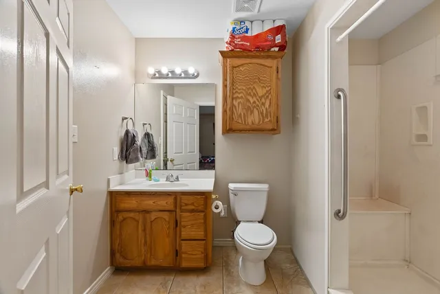 a bathroom with a toilet sink vanity and mirror