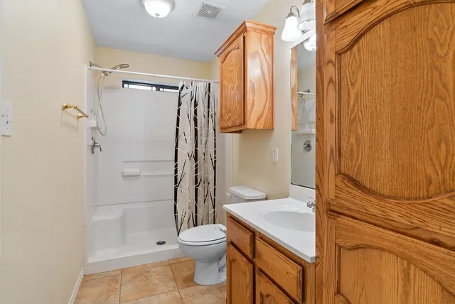 a bathroom with a granite countertop sink toilet and shower