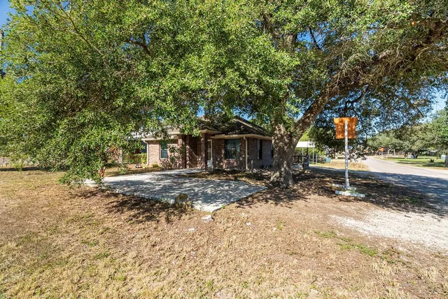 a view of a house with backyard and sitting area