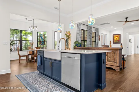 a kitchen with a sink stove and wooden floor